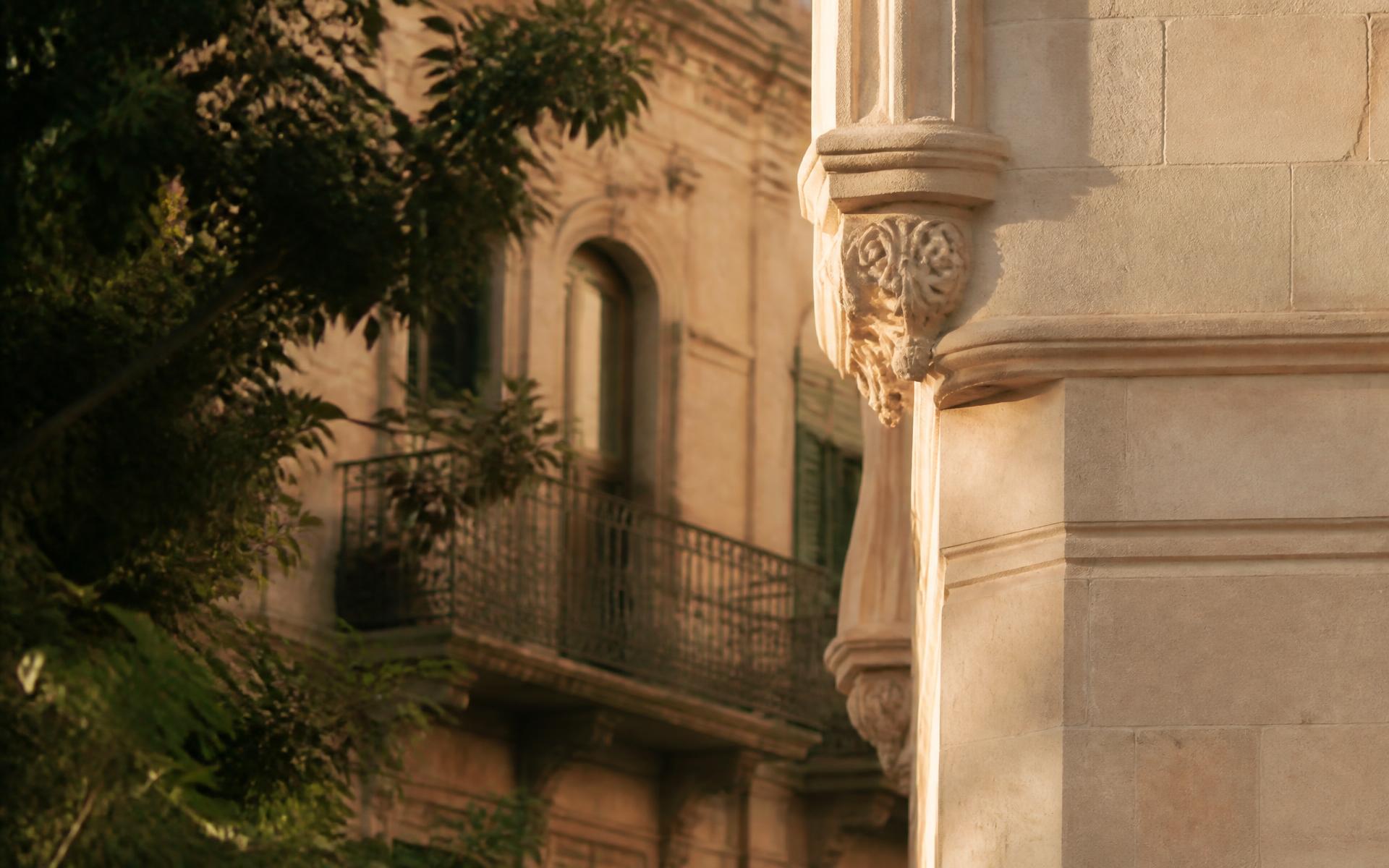 Fachada de piedra de un edificio clásico en Barcelona a última hora de la tarde